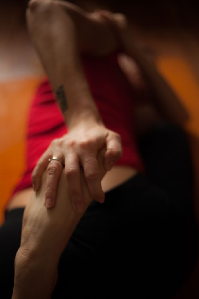 The Art of Drawing Readers In: Your attractive post title goes here Intimate close-up of a person in yoga pose, hand holding foot with focus on movement and form.